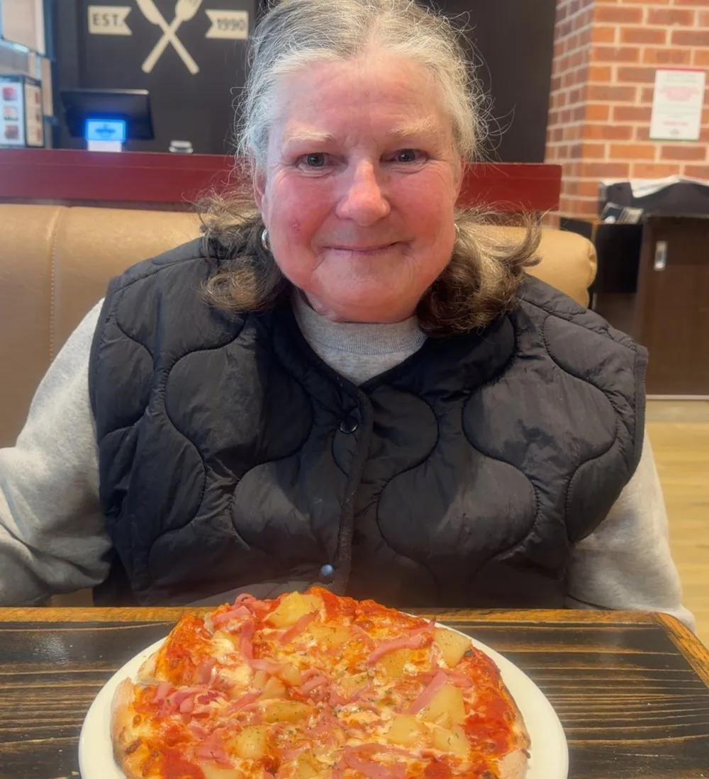 A client enjoying lunch out at a local pizza restaurant during a supported outing