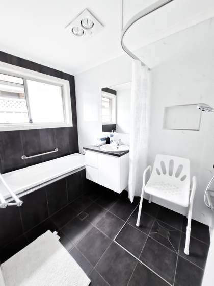 Accessible bathroom with grab rails and shower chair