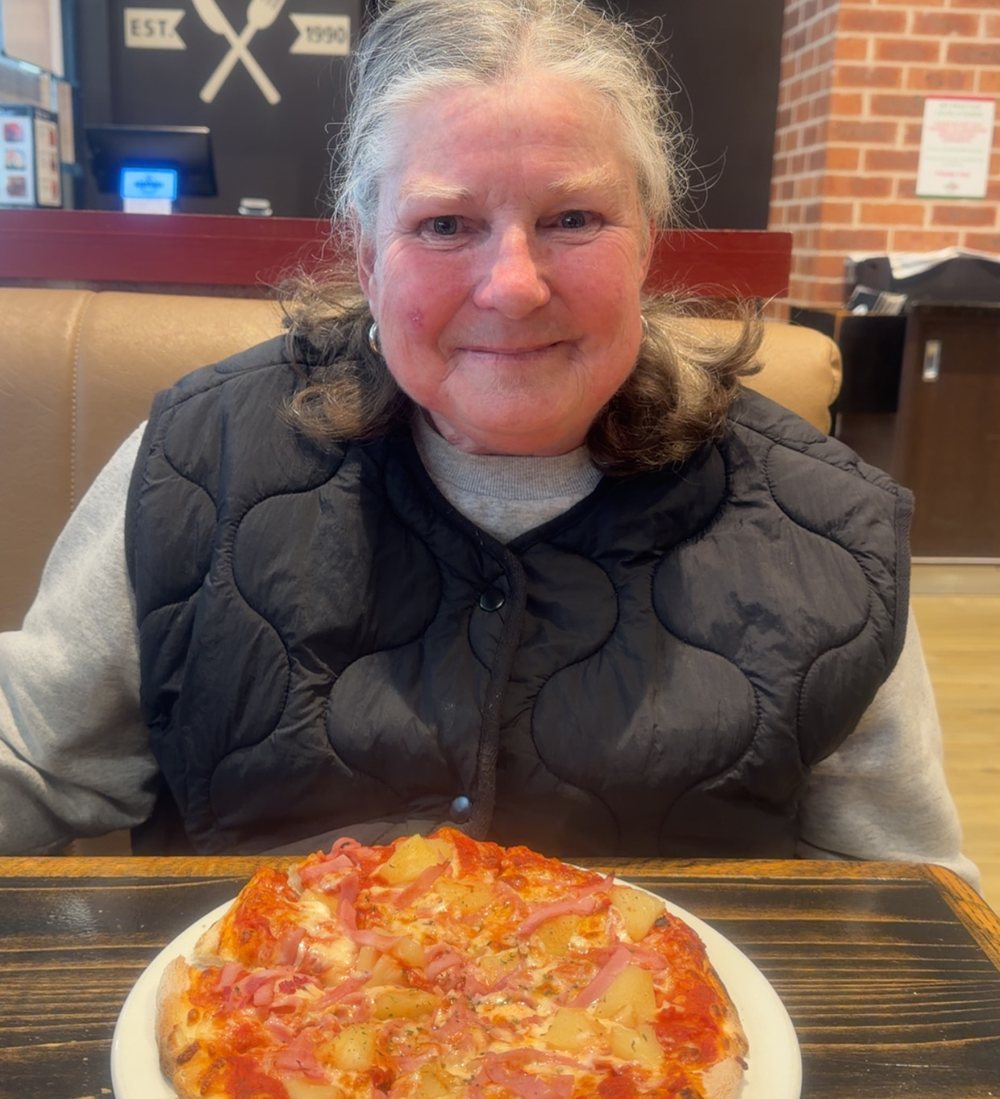 A client enjoying lunch out at a local pizza restaurant during a supported outing