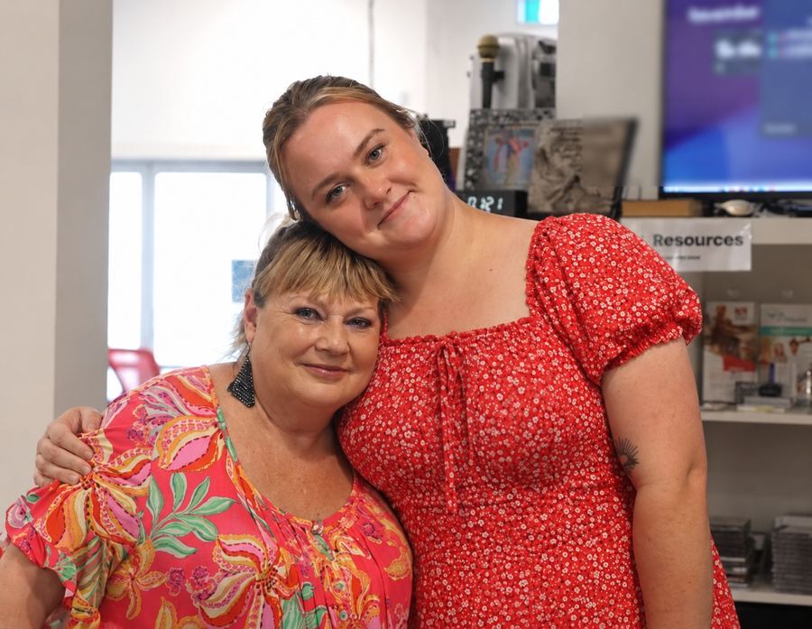 Two women sharing a warm hug at a Beyond community day