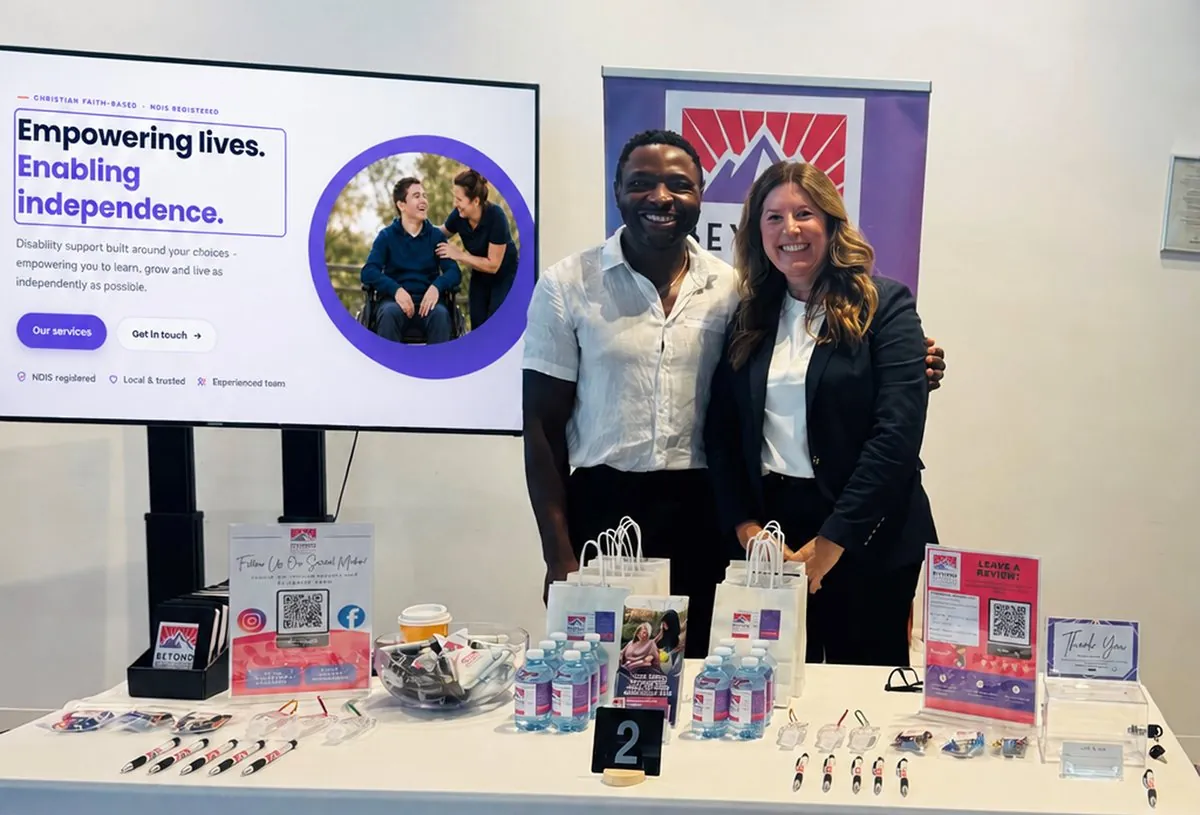 The Beyond team at a community expo stand, with the new Beyond website on the screen behind them